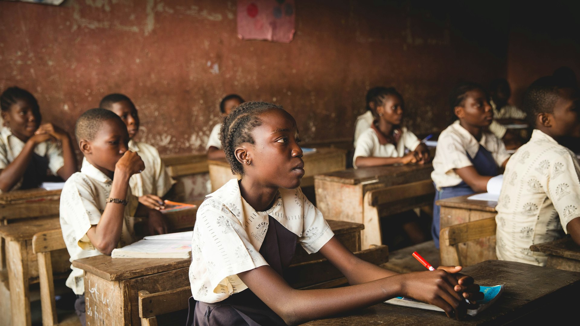 children sitting chairs inside classroom